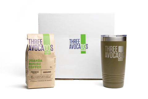 A white box, brown bag of coffee, and green tumbler all against white backdrop