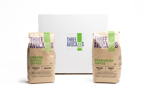 Two bags of coffee in front of a white gift box