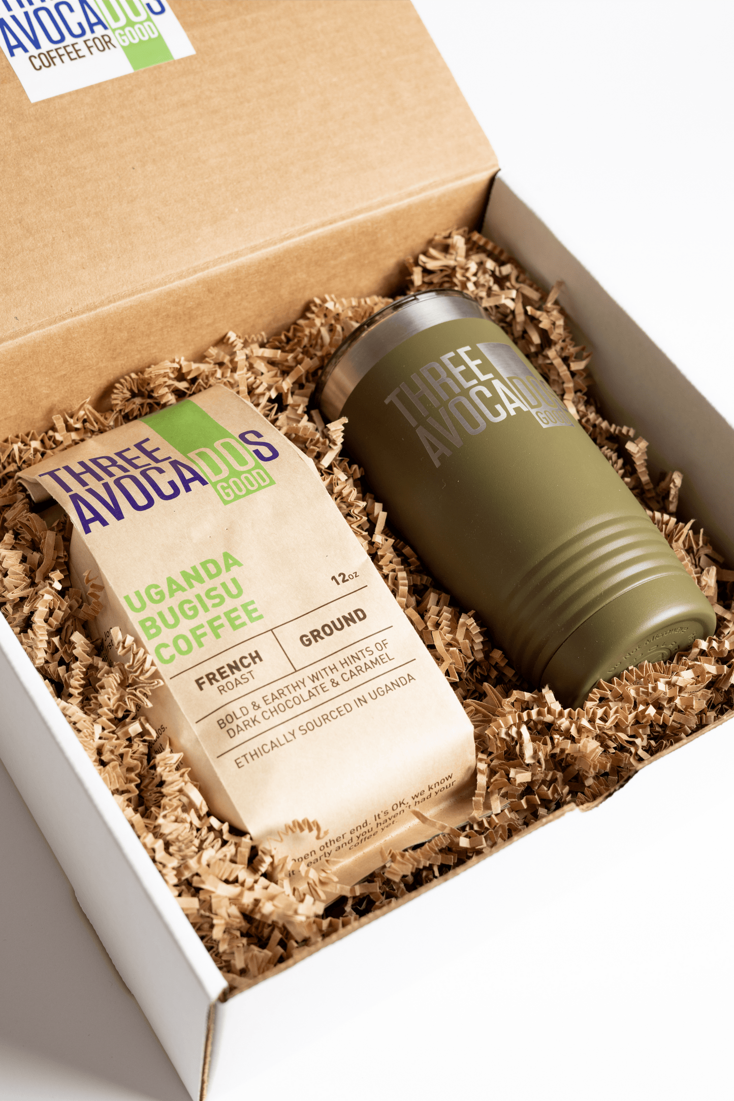 A brown bag of coffee and green tumbler inside of a box, lid open
