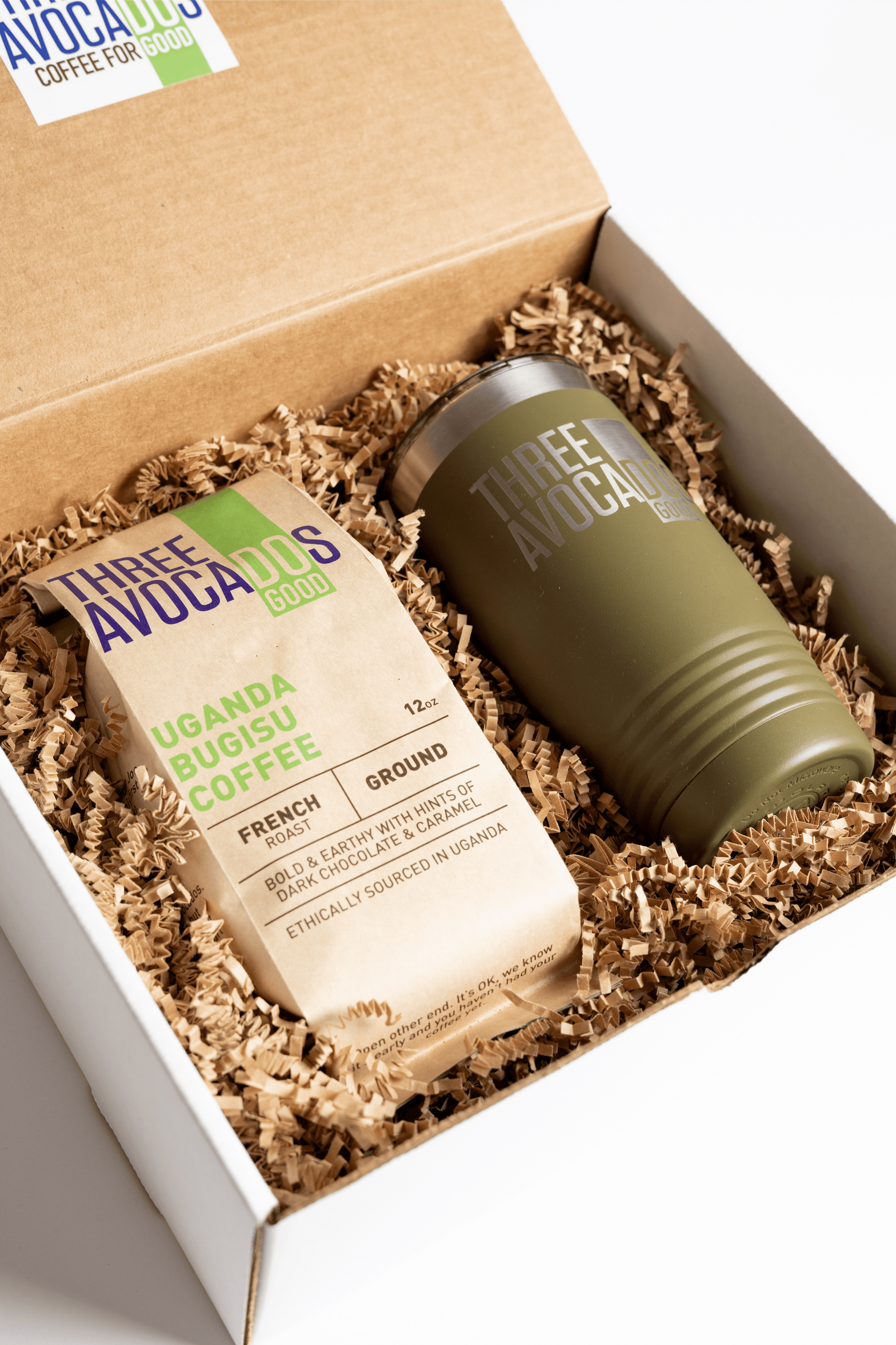 A brown bag of coffee and green tumbler inside of a box, lid open