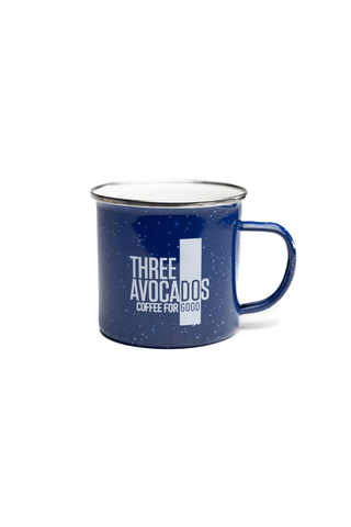 A blue enamel mug saying "Three Avocados Coffee For Good"