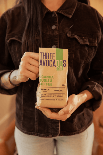 A woman holds a bag of Ugandan coffee